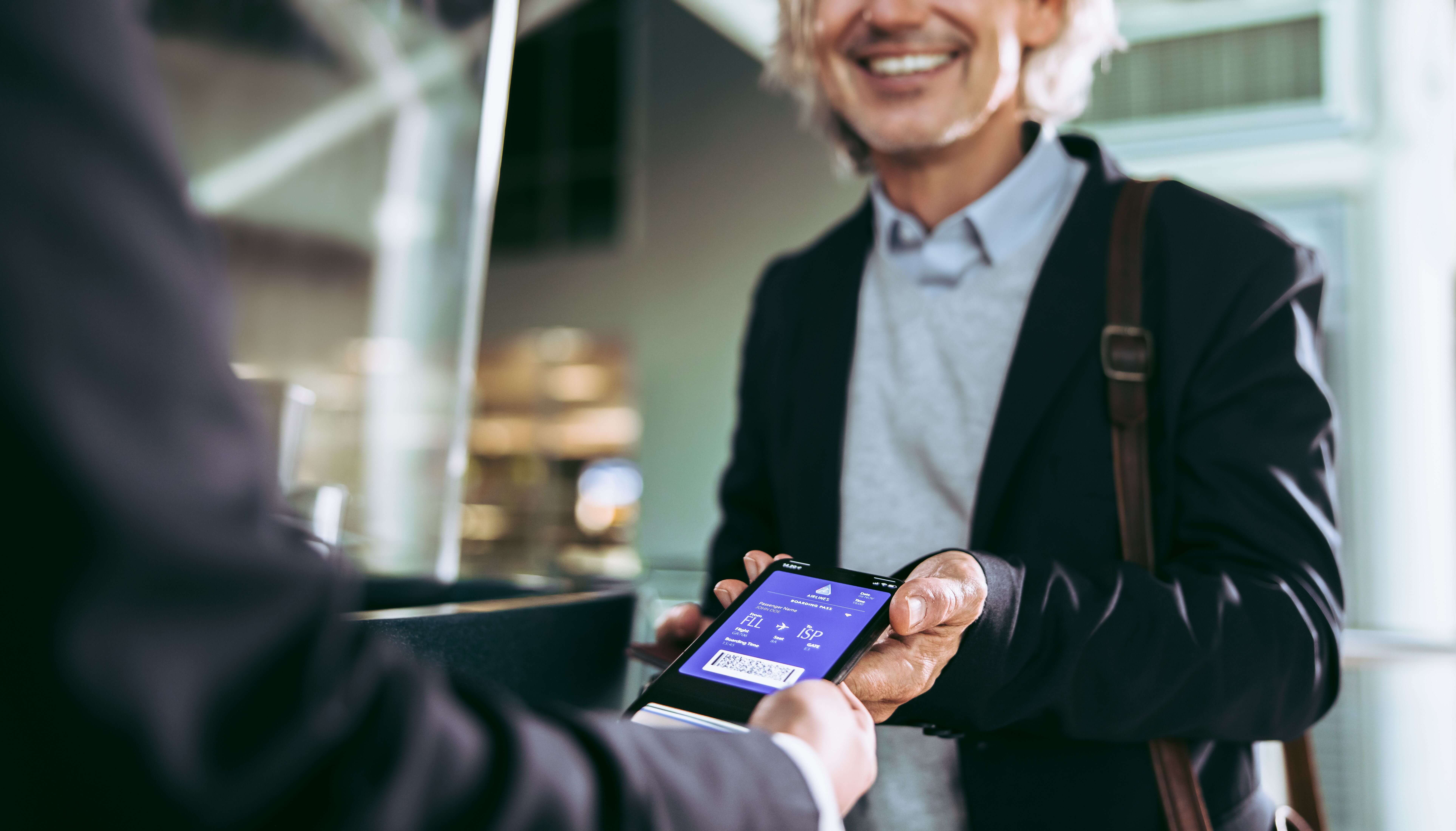 Man showing mobile boarding pass to TSA agent 