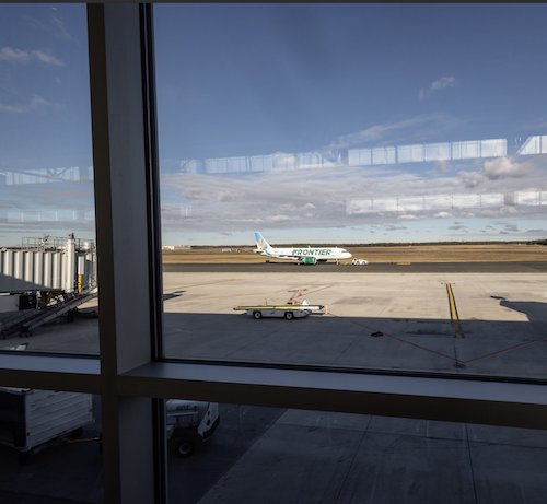 A Frontier airplane sitting on the runway at Long Island MacMarthur Airport