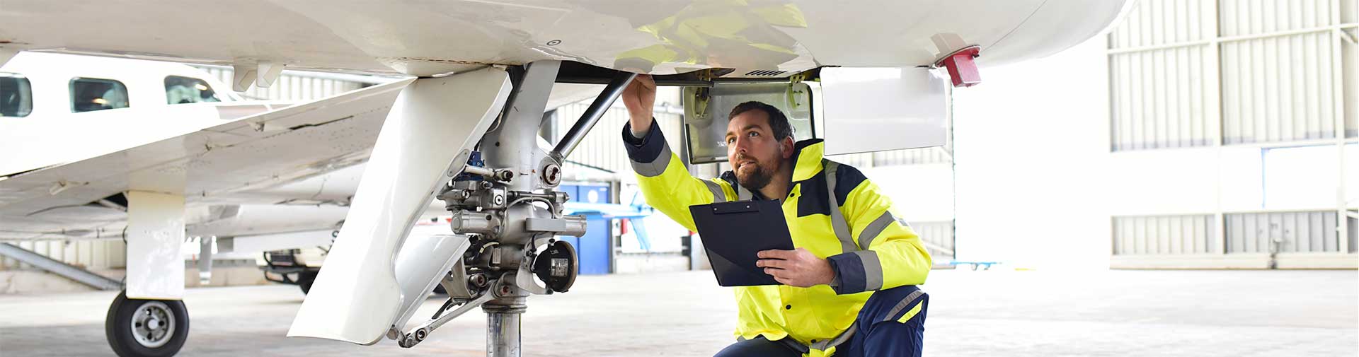 Airport crew member inspecting plane