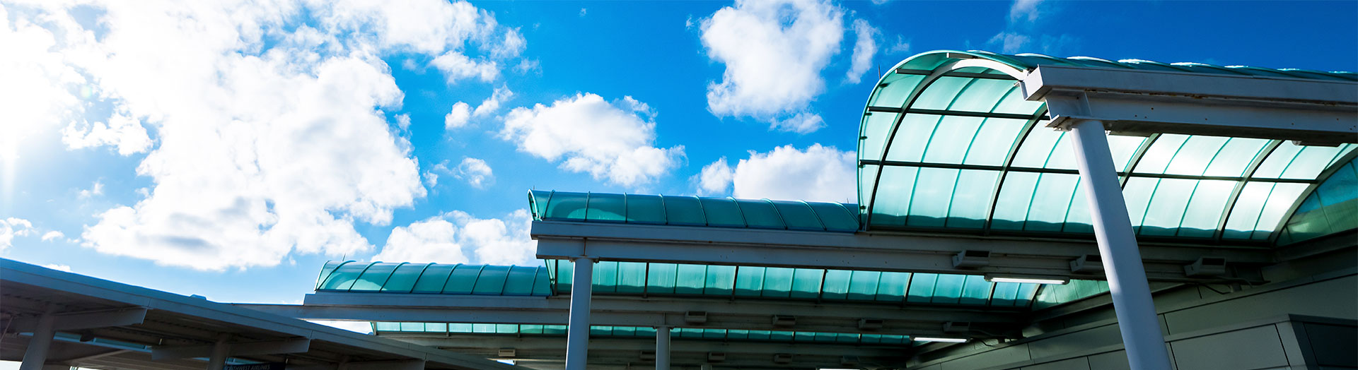 Outside of airport building with blue sky.