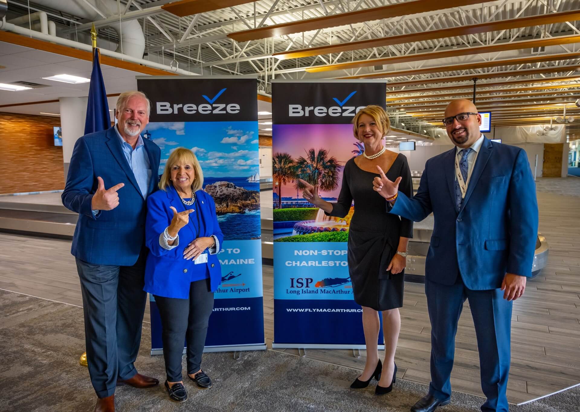 Group picture of ISP Staff in front of Breeze signs to celebrate new nonstop flights